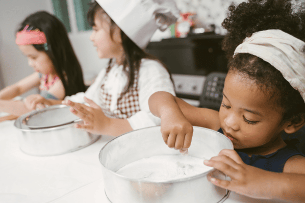 Children learning how to bake items on their daycare menu